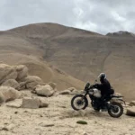 Rider on a Ladakh motorcycle tour among rocky Himalayan hills