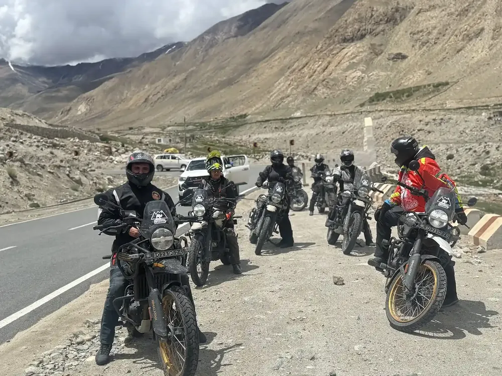 Group of riders on Royal Enfield Himalayan motorcycles on a mountain road in the Himalayas