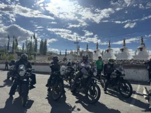 D'Himalayan Riders motorcycles lined up by white stupas in Ladakh
